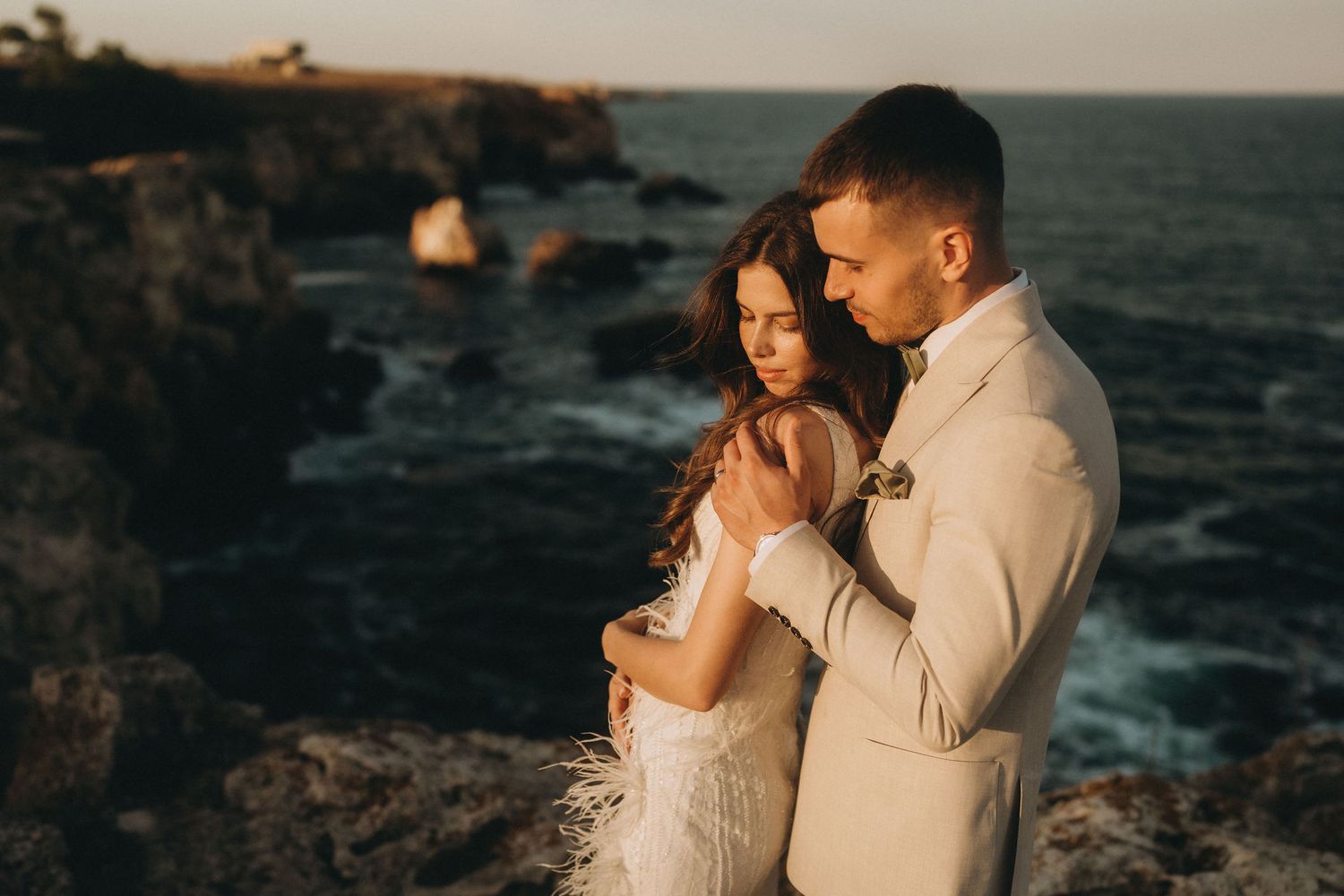 A romantic sunset moment captured on dramatic ocean cliffs during golden hour.