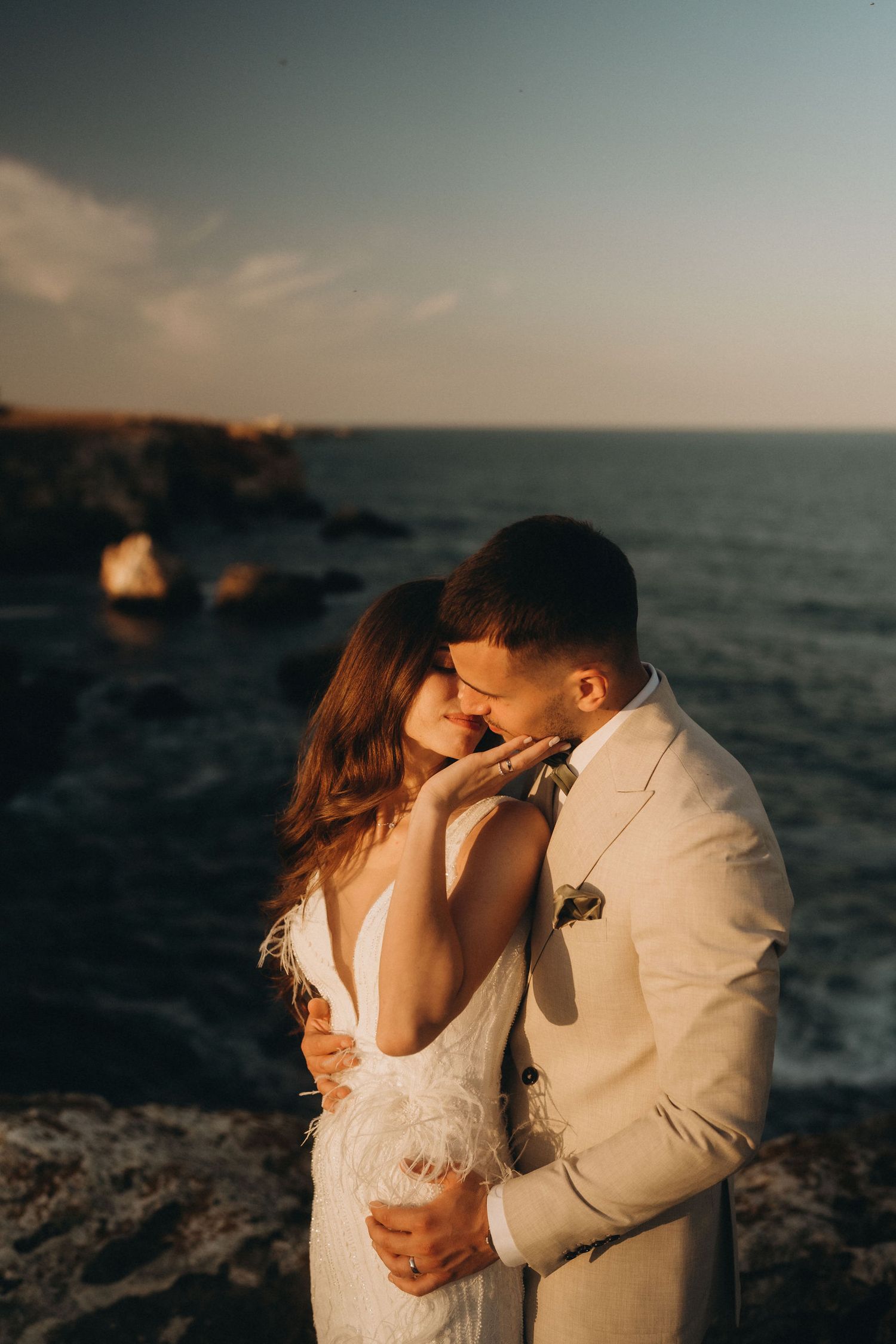 An intimate moment captured during a coastal sunset photoshoot.