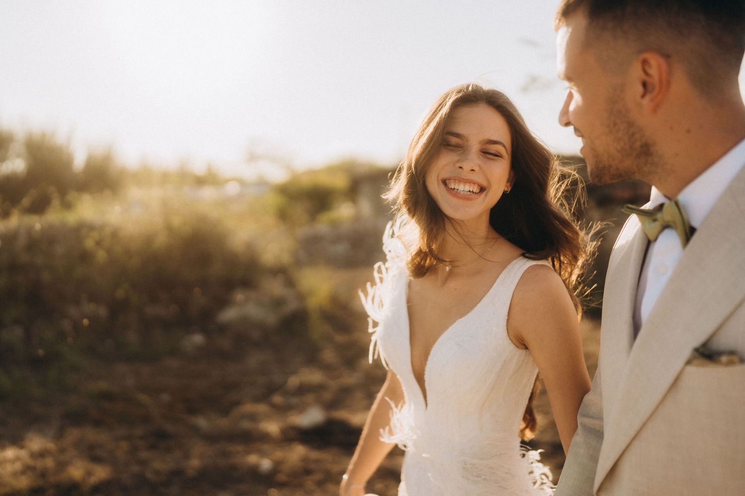 Romantic sunset portrait of newlyweds sharing an intimate moment in golden hour light.