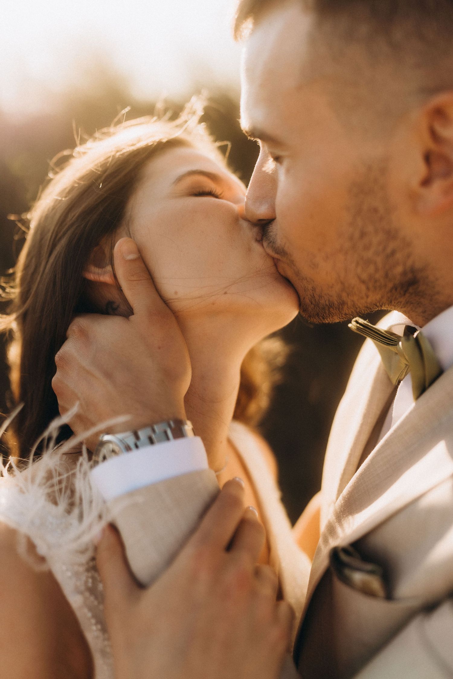 Intimate close-up of a wedding couple sharing a passionate kiss in golden hour light.