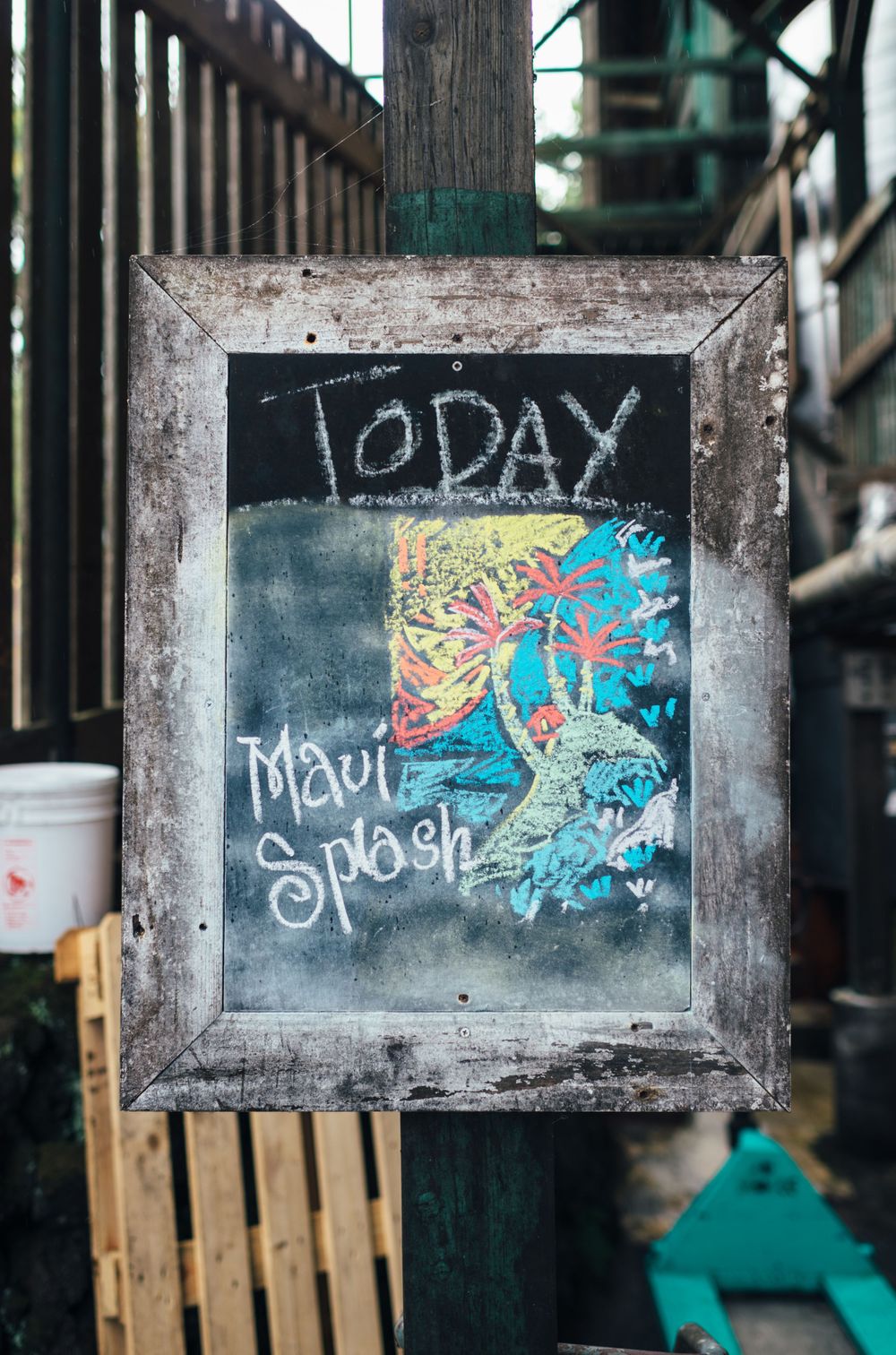 Rustic chalkboard sign displaying 'Today Maui Splash' with colorful artwork.