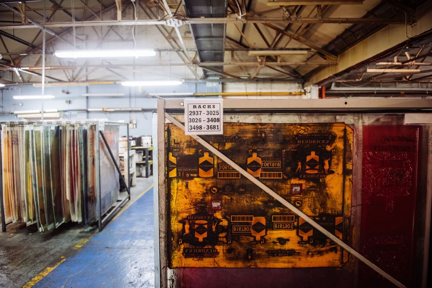 Dimly lit industrial storage area with metal shelving units and equipment visible in the background.