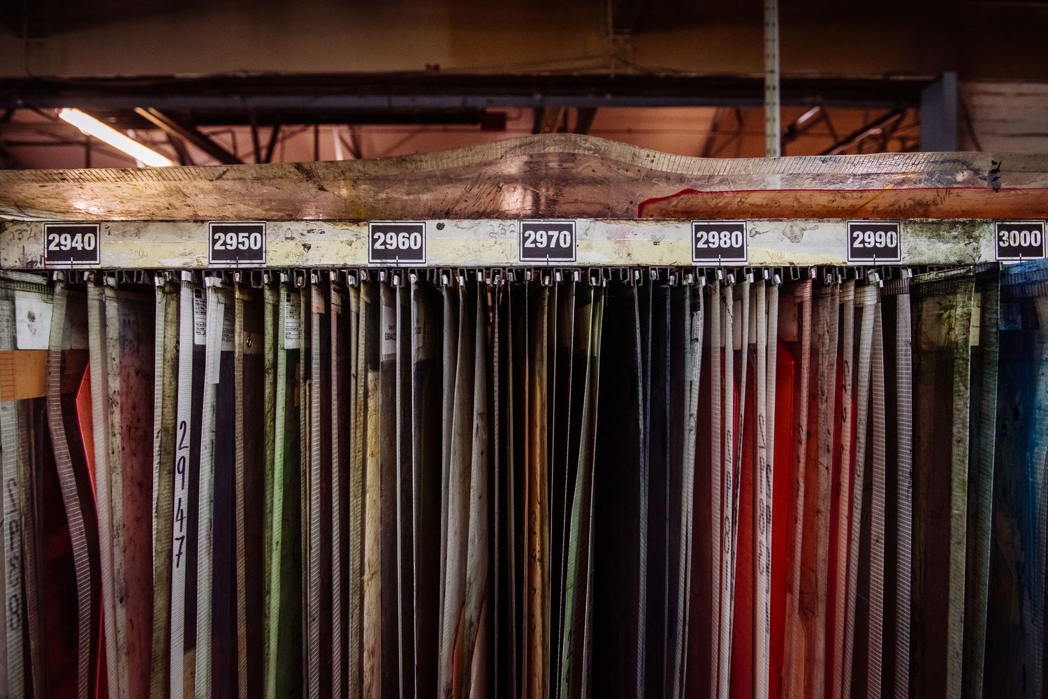 Organized rack system displaying various colored materials in a manufacturing facility.