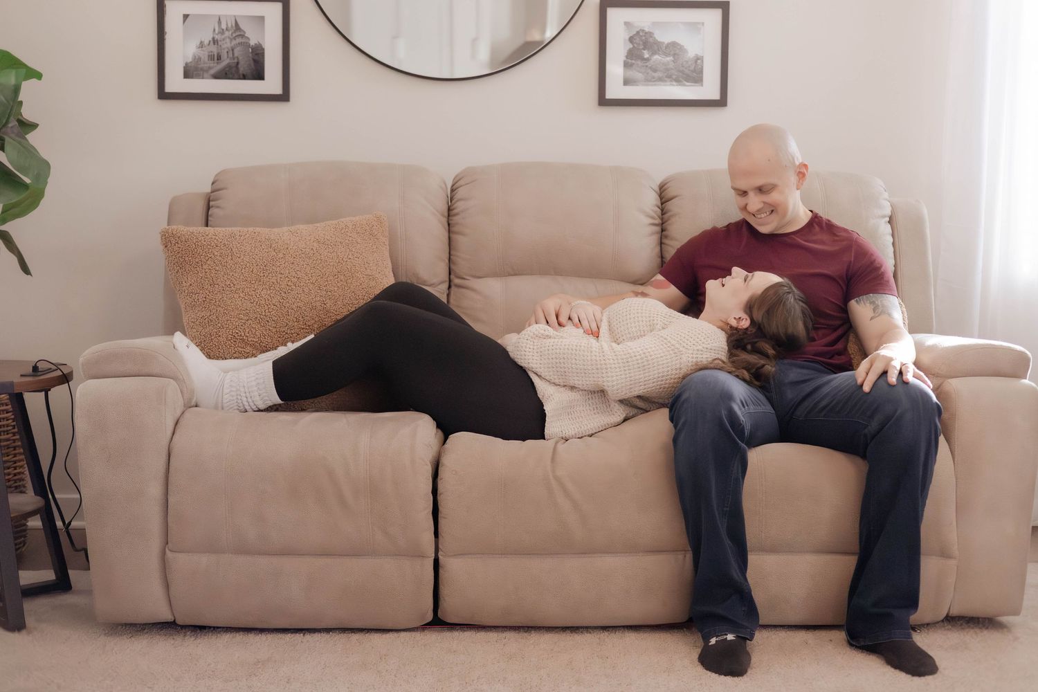 Pregnant woman smiling at home with hand on belly, capturing intimate and natural maternity moments, Northern Virginia photography