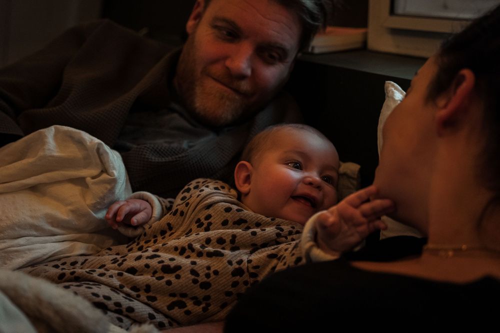 A series of candid photos showing a baby in leopard print clothing interacting with someone in various playful moments.