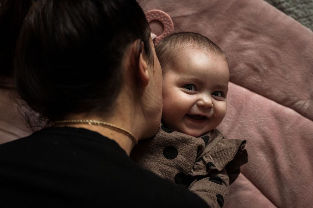 A series of intimate black and white photos showing tender moments between parent and baby in soft lighting.