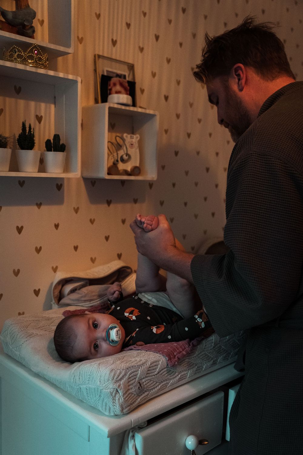 A series of four photos showing a bedtime routine with a baby being tucked in under soft lighting.