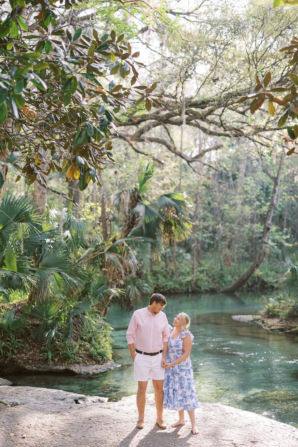 Jessica & her husband stroll along a serene spring surrounded by lush tropical foliage and overhanging trees at Kelly Park's Rock Springs.