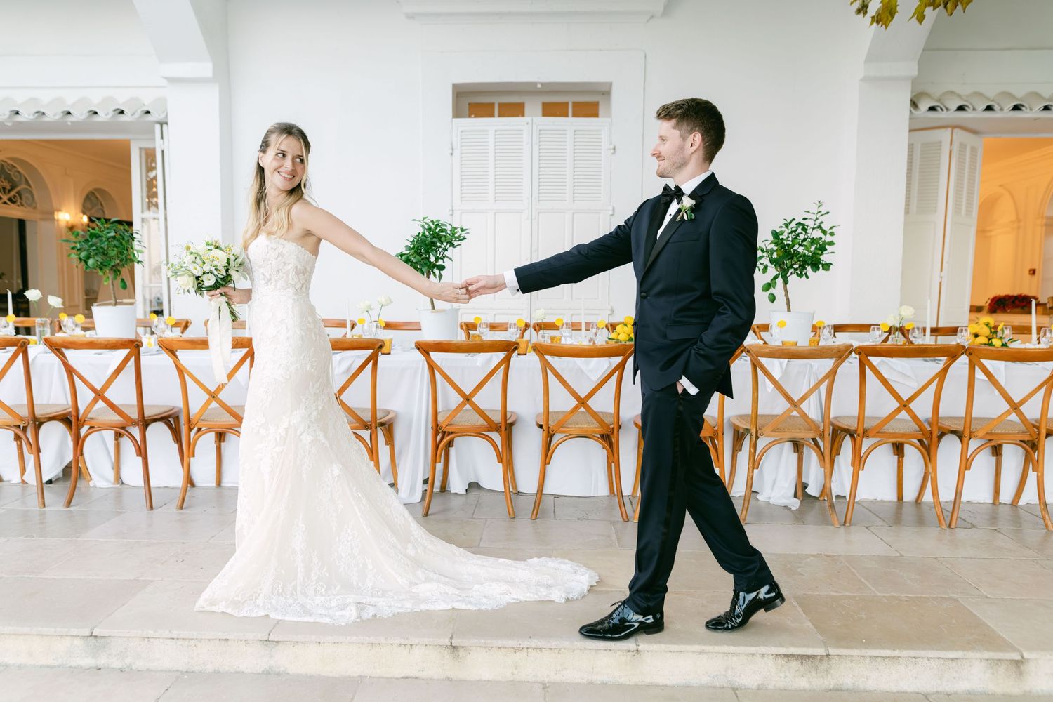 Wedding couple's feet in formal shoes walking together across a bright modern dining room floor.