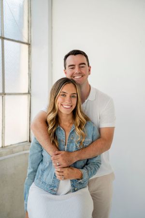 A couple in matching white and denim outfits pose playfully in a bright studio setting with multiple candid shots.