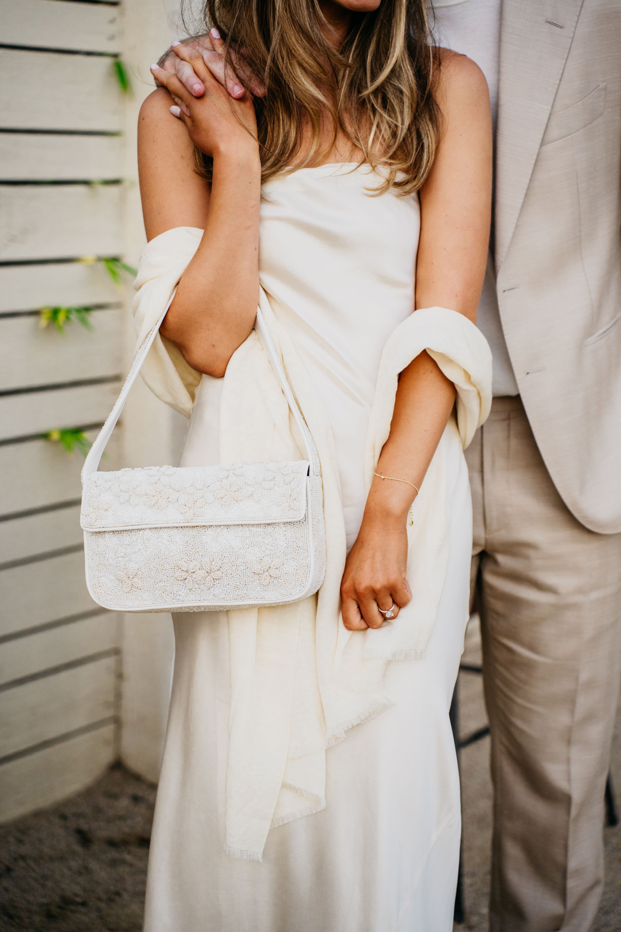 Close-up detail shots showing hands and white fabric in an intimate wedding photography series.