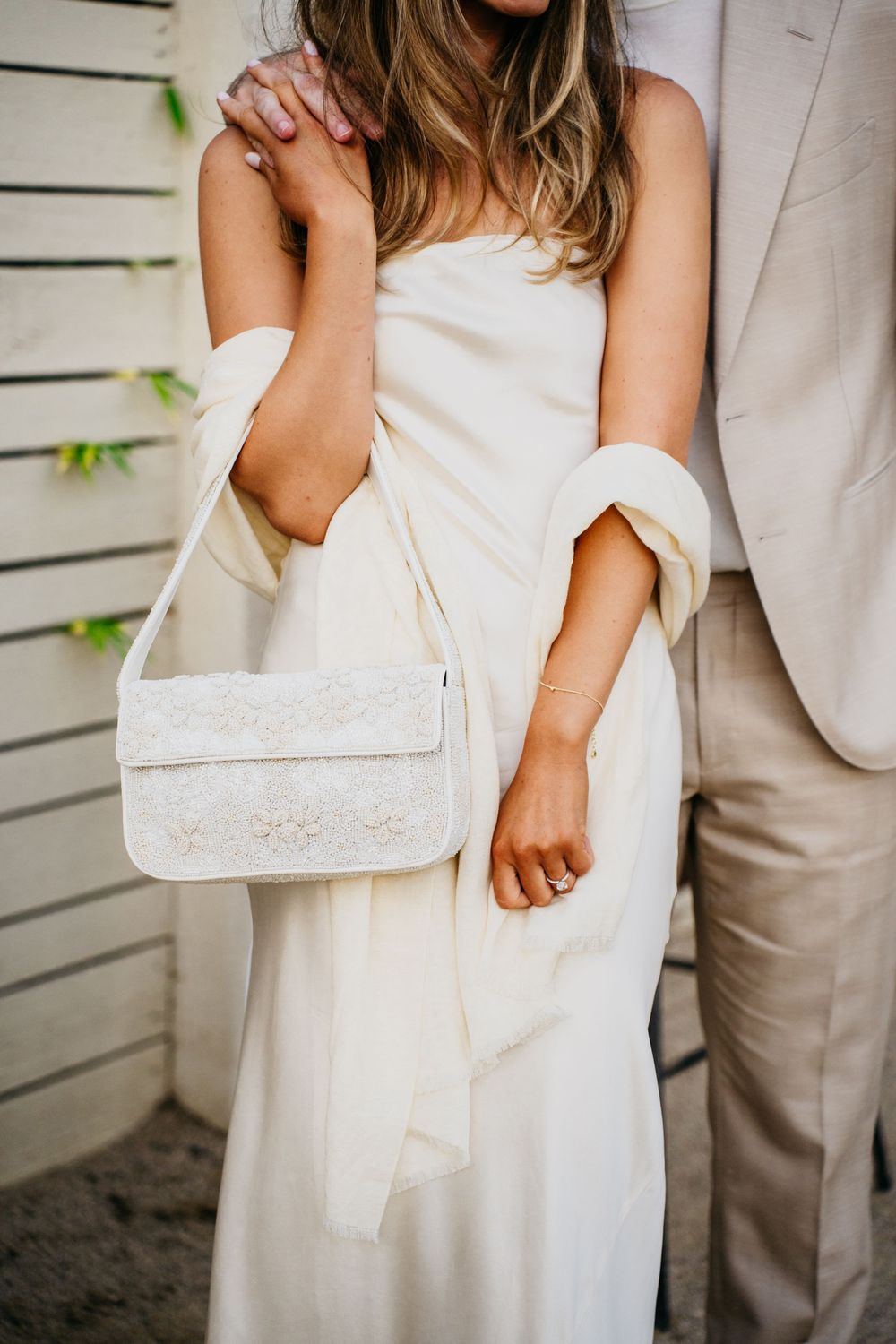 Close-up detail shots showing hands and white fabric in an intimate wedding photography series.