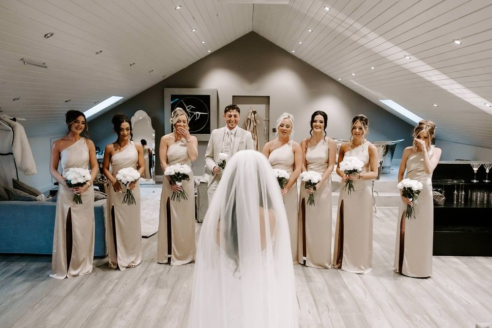 A panoramic collage of wedding party members in light colored formal attire posing together indoors.
