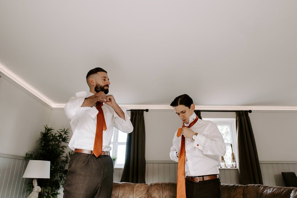 A couple dancing together in a bright, modern room with white walls and dark curtains.