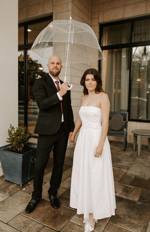 Romantic sequence showing a couple with clear umbrellas outside on a rainy day.