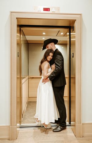 Romantic elevator photoshoot featuring couple in formal attire.