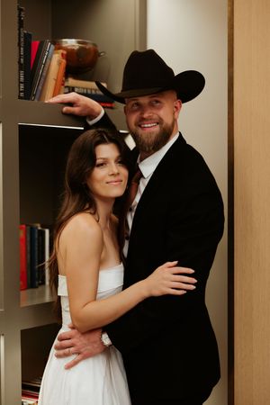 A couple shares tender moments during their photoshoot in a library setting.