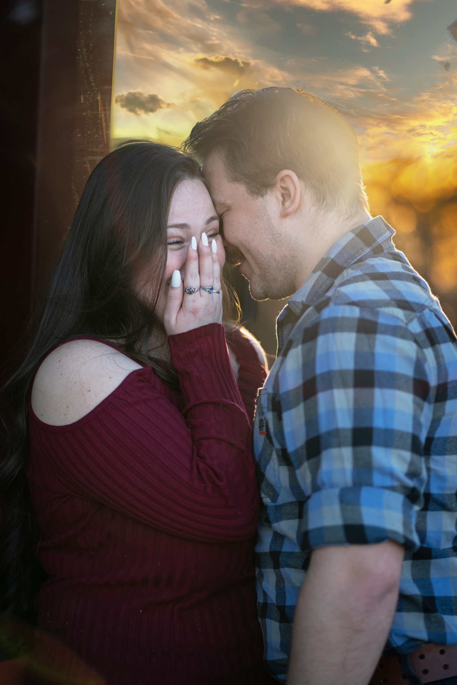 A romantic couple shares an intimate moment at sunset, during an engagement session