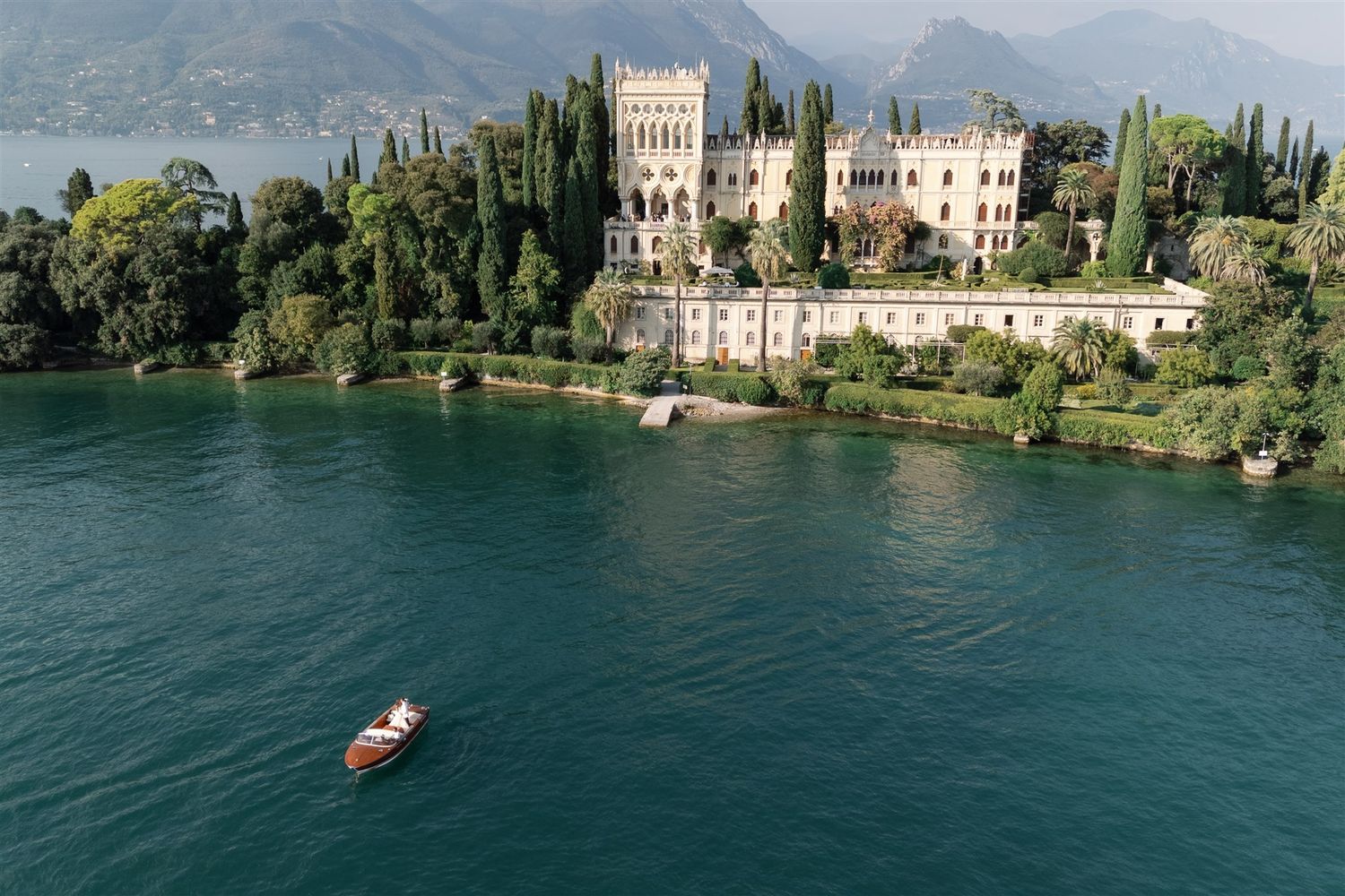 Italian-American couple arriving by boat at Isola del Garda for their wedding reception
