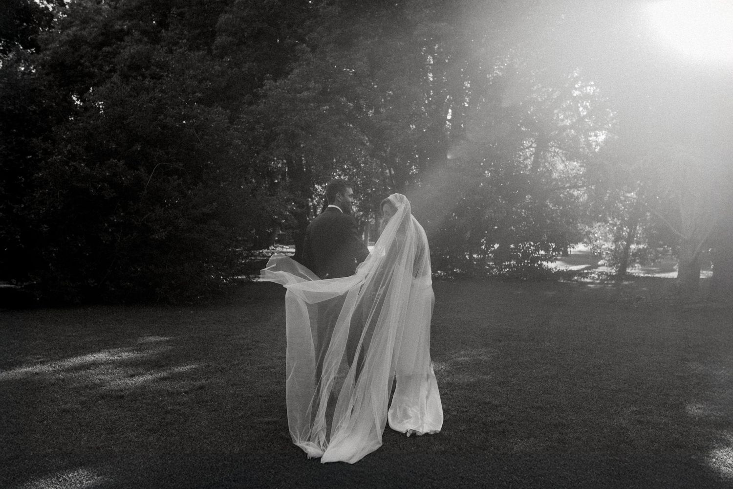 A series of black and white photos showing a ghost-like figure in white fabric moving through a dark wooded area.