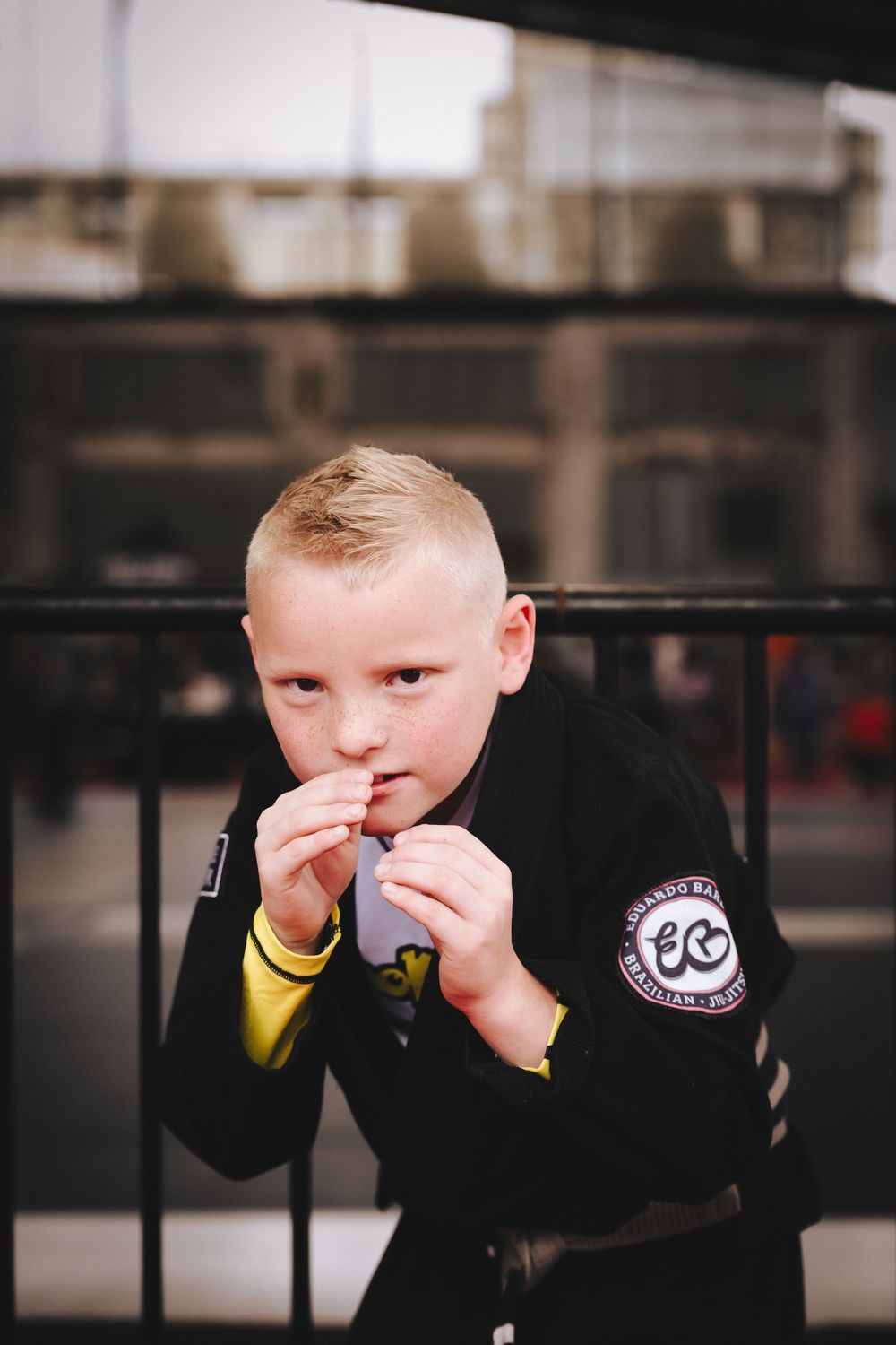 Young martial arts student in black uniform posing in fighting stance.