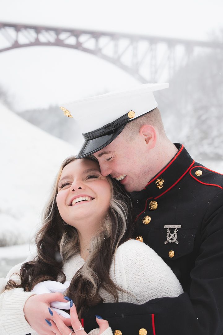 Romantic winter scene with snow falling near a bridge.