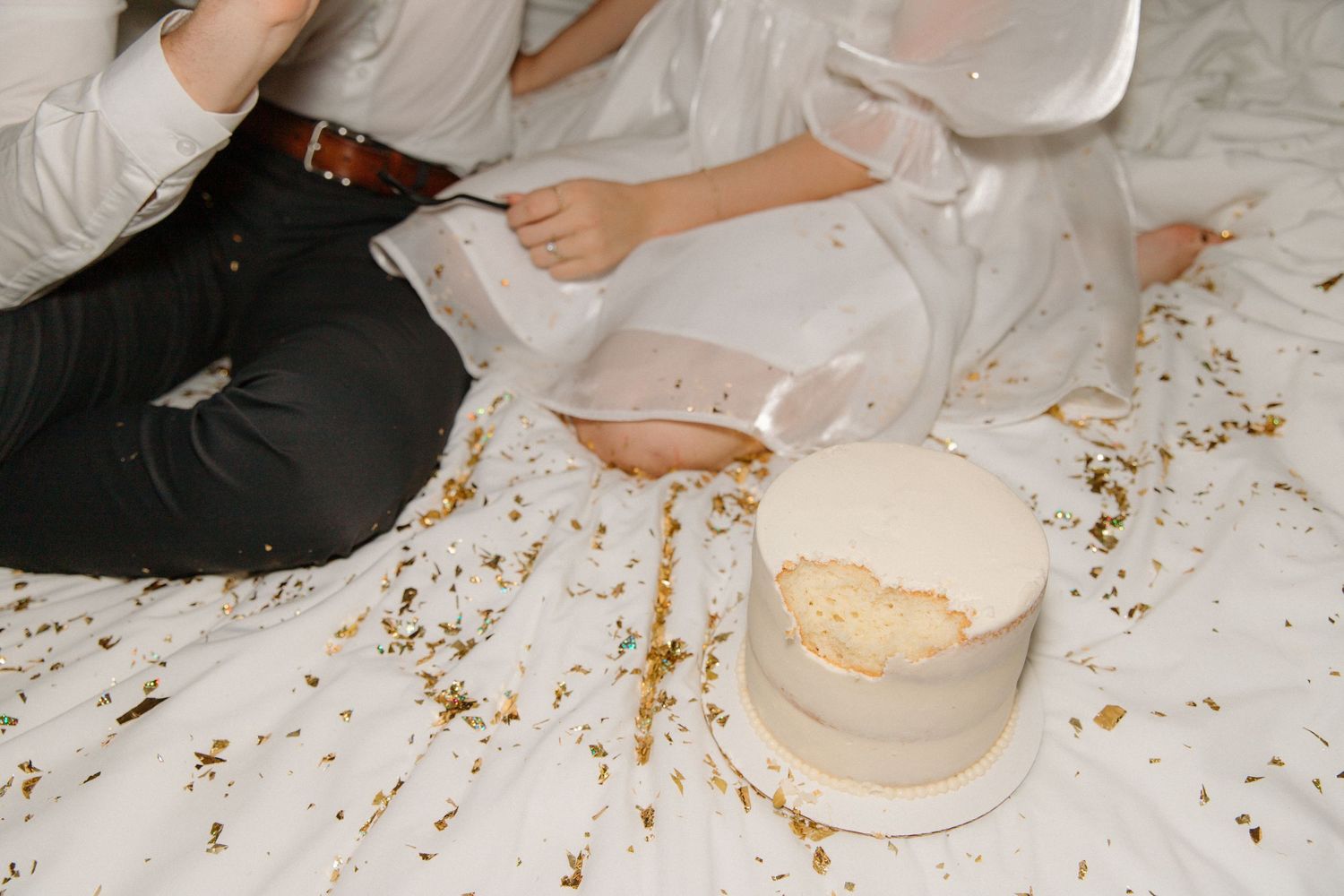 Hands sprinkle breadcrumbs onto a white surface during food preparation in a cooking sequence.