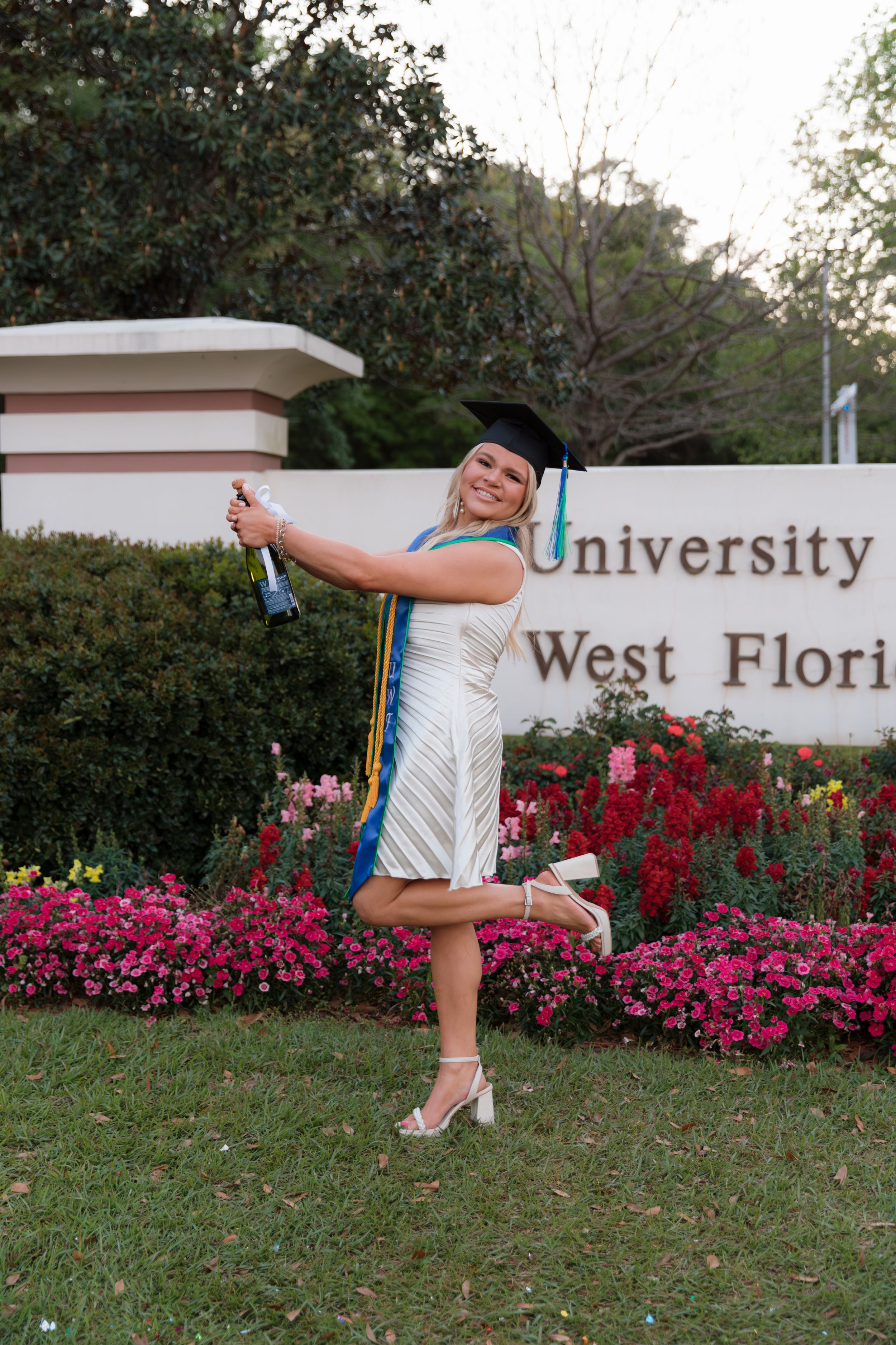 A playful series of photos showing someone doing cartwheels in front of a university sign with blooming pink flowers.
