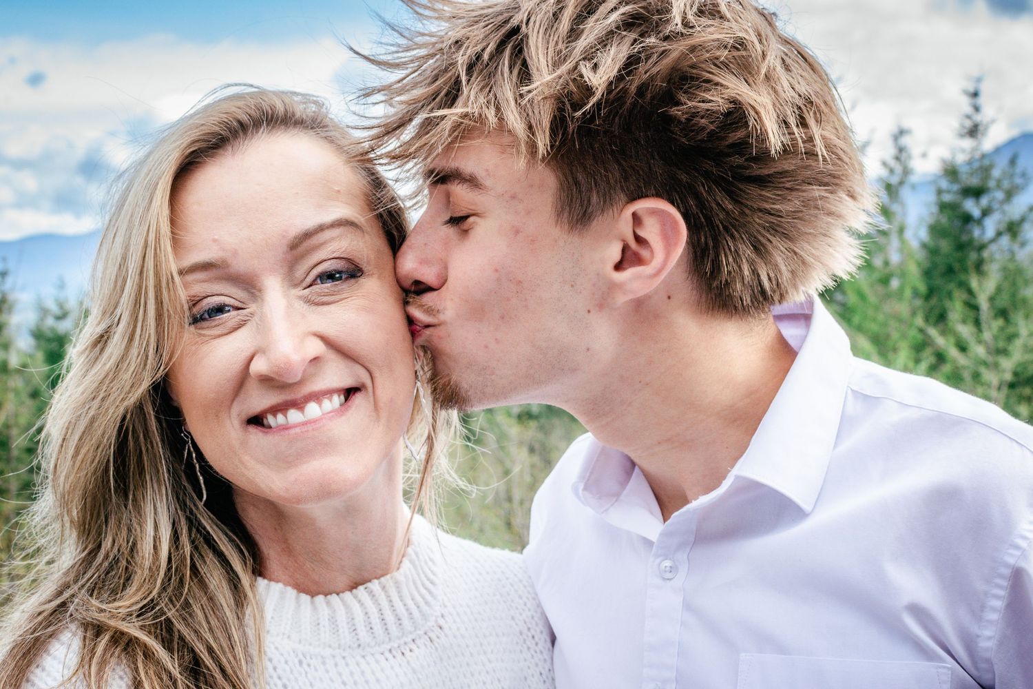 Graduate kisses his mother’s cheek during a joyful senior session at Snoqualmie Point Park—celebrating family and graduation together.