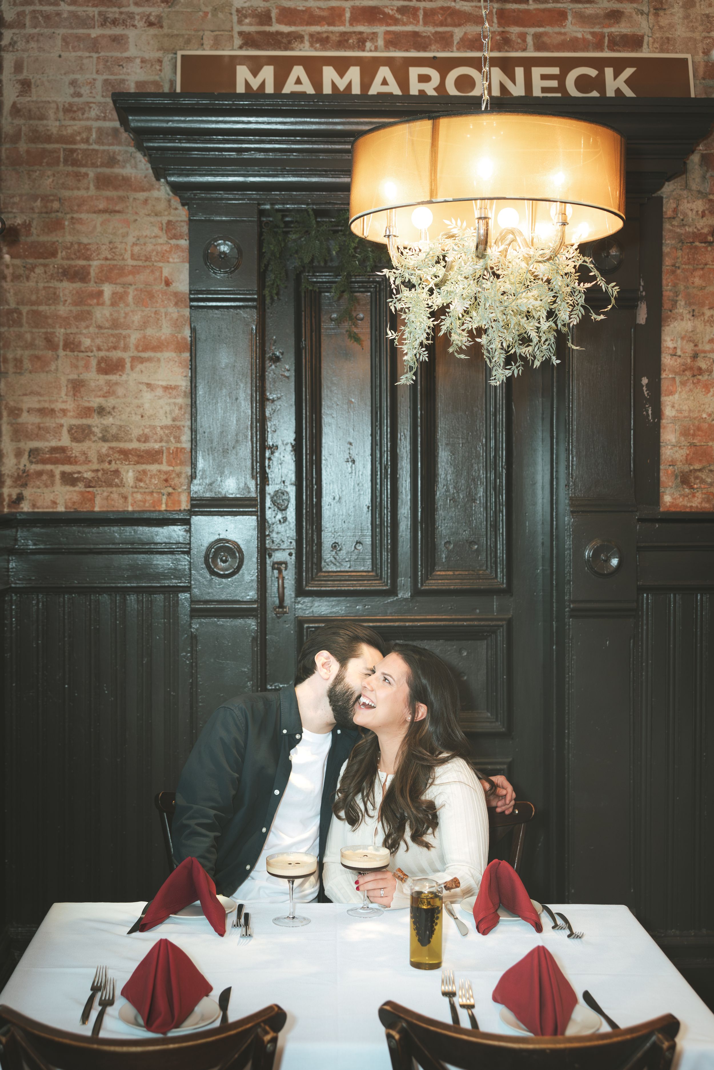 Three connected photos show a cozy restaurant interior with exposed brick walls, dark wood paneling, and elegant table settings.