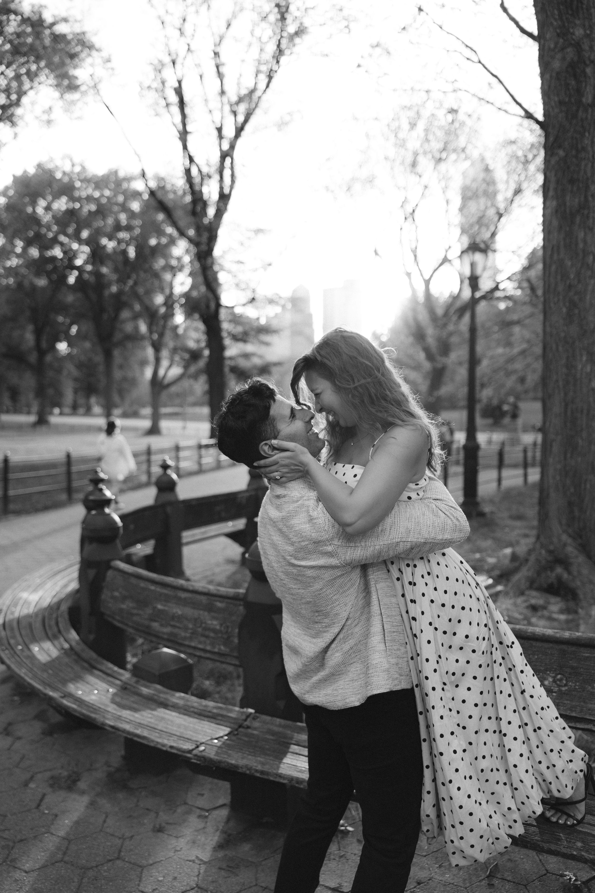 A romantic black and white photo series of a couple dancing and embracing on a park bench.