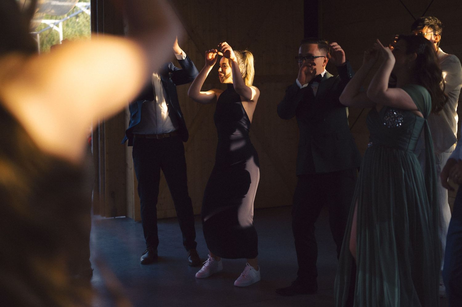 People dancing and mingling at a dimly lit party or nightclub event.