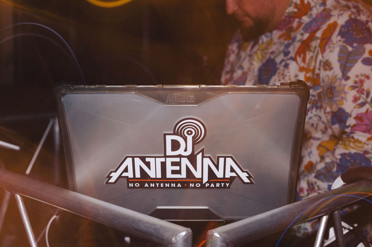 A DJ setup with vintage equipment featuring a laptop with the DJ Antenna logo displayed on the screen.