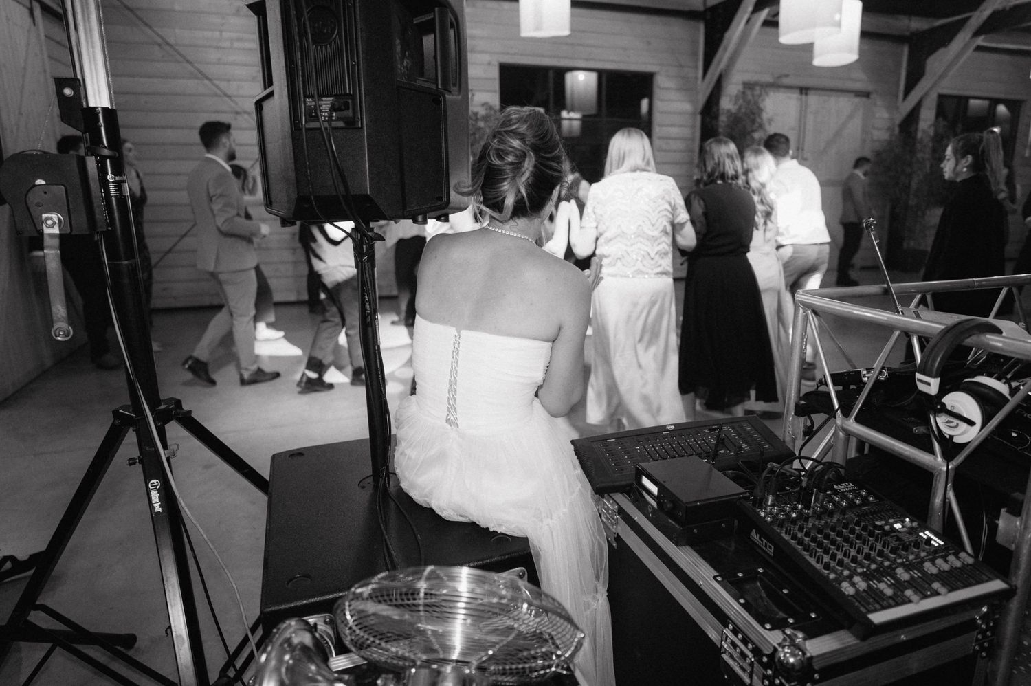 Black and white photo of a music recording session with studio equipment and musicians in a sound booth.