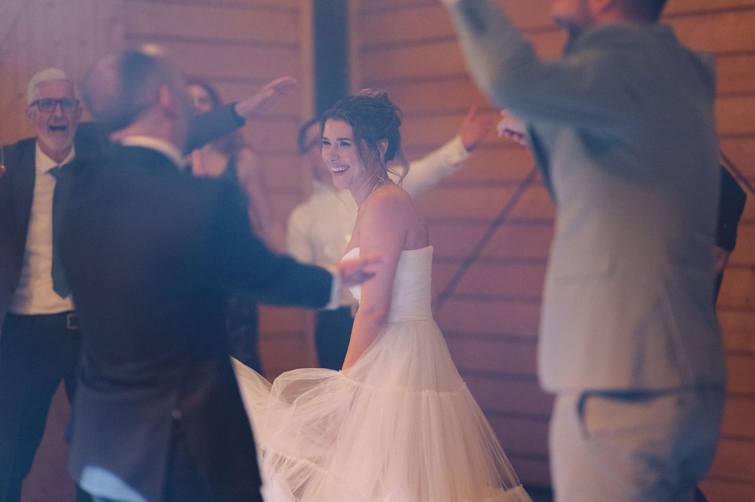 People enjoying a dance at a wedding reception with soft lighting and a dreamy atmosphere on the dance floor.