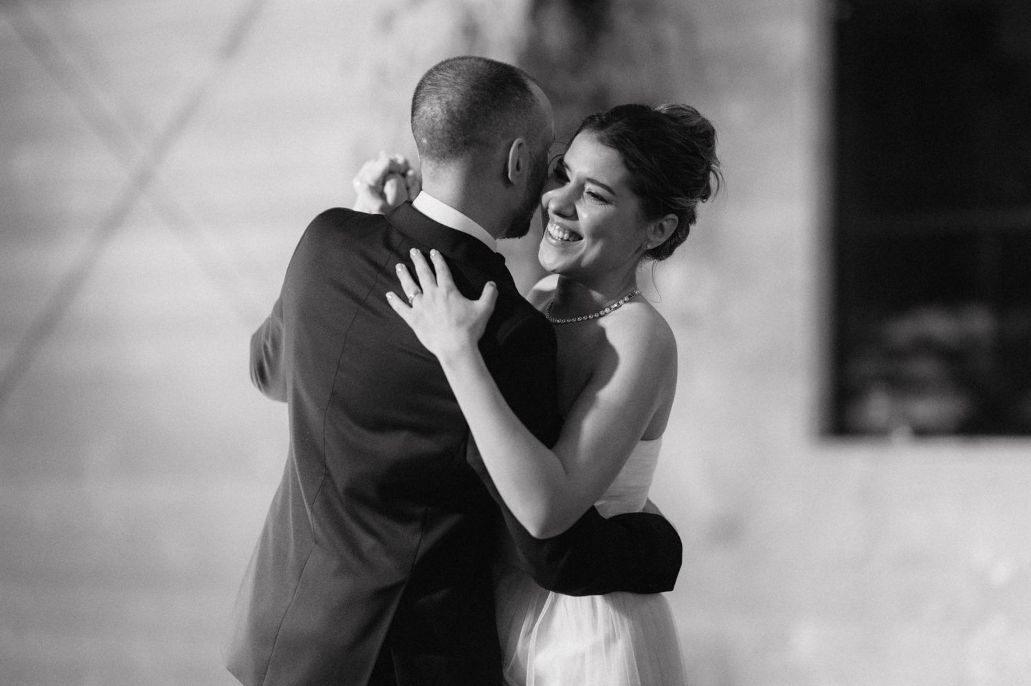 A romantic black and white photo of a couple sharing an intimate dance at their wedding reception.