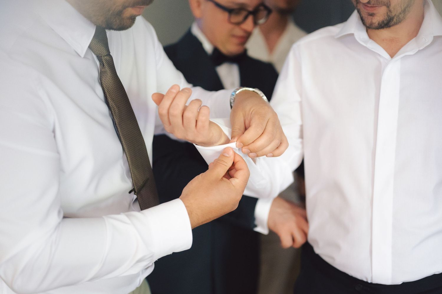 Several people in business attire examine and interact with something small in their hands in an indoor setting.