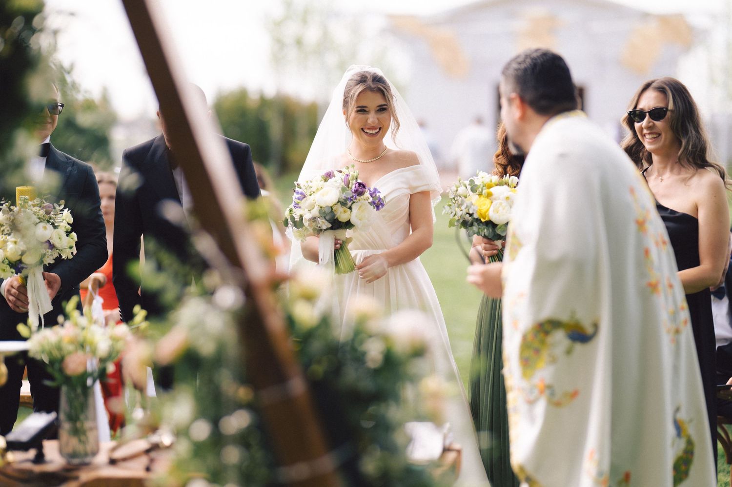 Outdoor wedding ceremony with flowers and decorations in a sunlit natural setting.