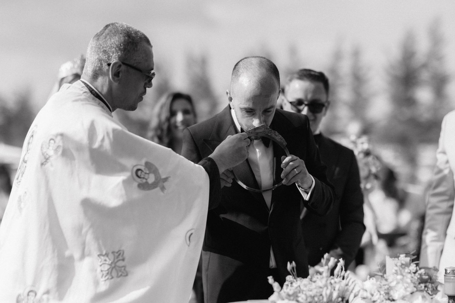 A black and white photograph of people gathered outdoors during a ceremony at what appears to be an event.