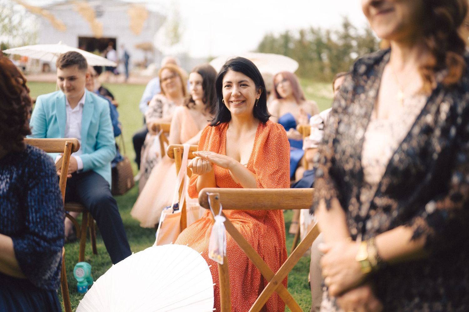 Guests enjoying an outdoor celebration with director-style chairs and festive decor in a garden setting during golden hour.