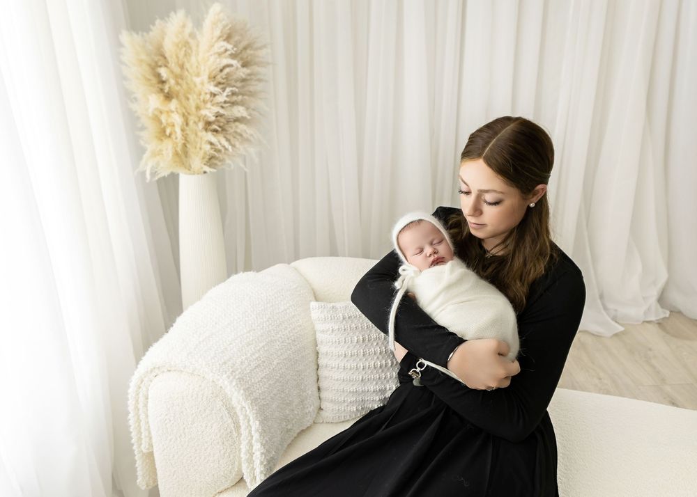 Minimalist nursery scene with pampas grass decor and white couch.