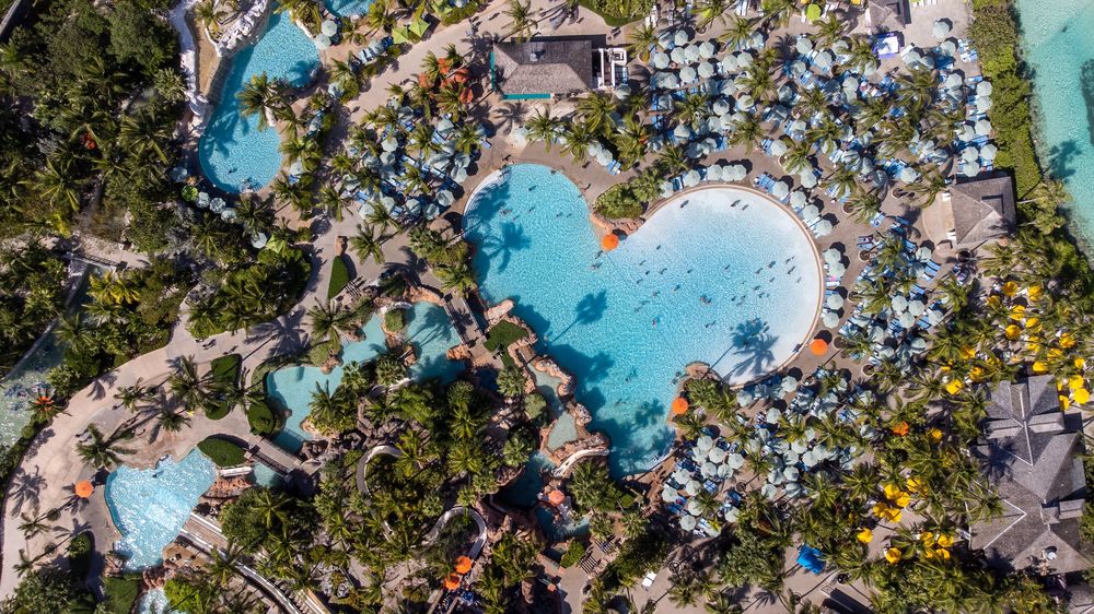 Aerial panorama of a tropical resort featuring multiple pools and beach access.