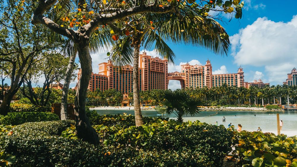 Iconic Atlantis resort in the Bahamas viewed across manicured tropical gardens with palm trees.
