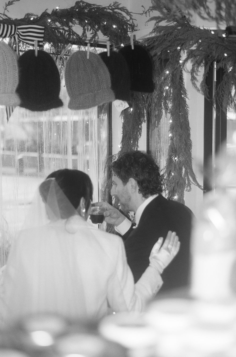 Atmospheric black and white wedding reception scene with decorative lighting and silhouettes.