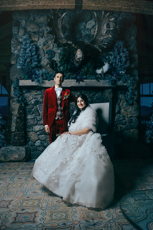 A couple in wedding attire poses in a stone room with ornate tiled floors and dramatic lighting in lake Placid, NY.