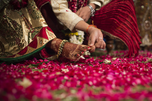 Henna adorned foot traditional Indian bride being guided by the groom. Intimate close shot.