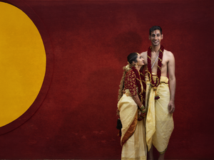 Artistic portrait against red and yellow backdrop featuring couple in traditional South Indian attire.