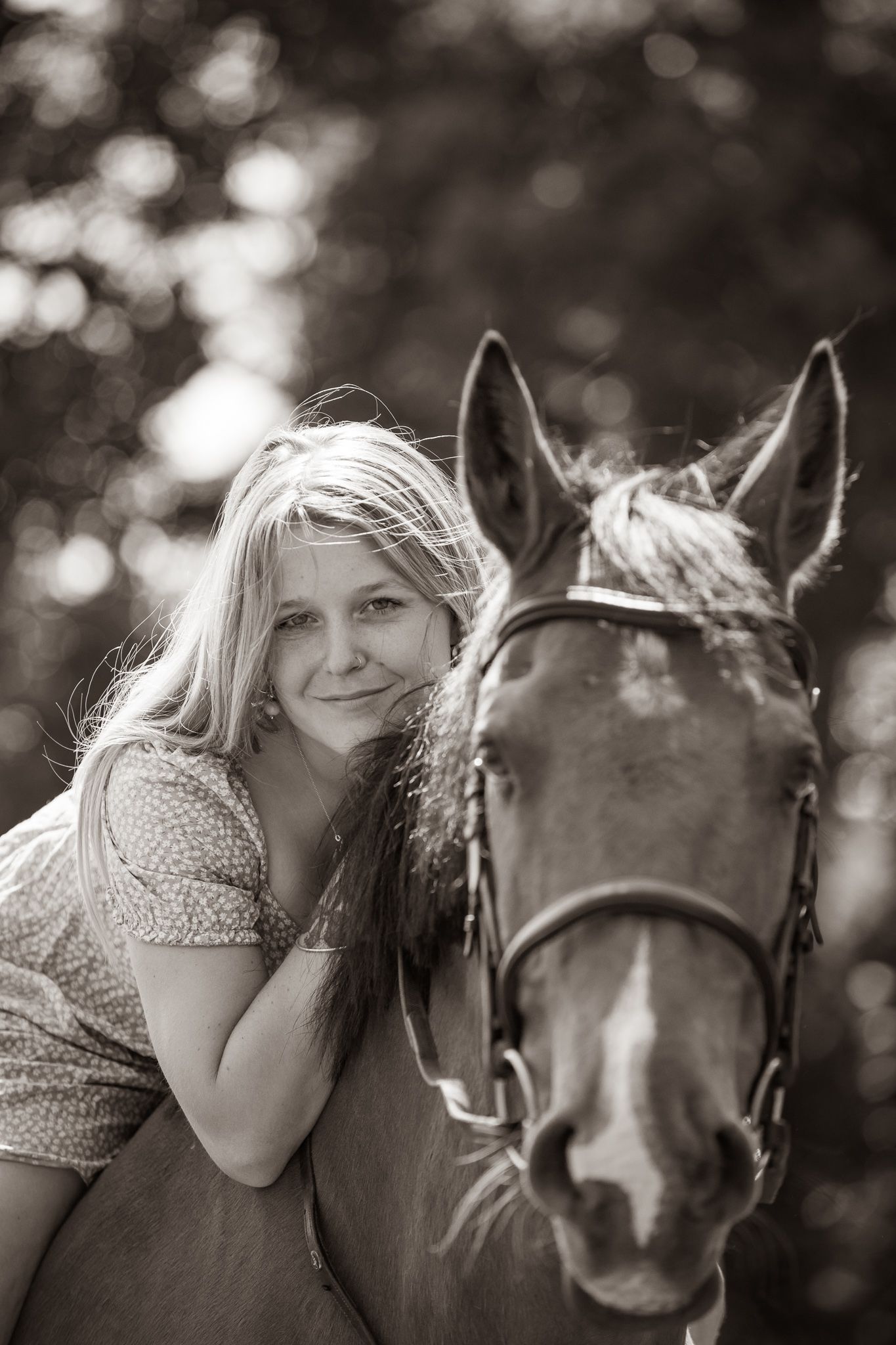 Young equestrian poses with palomino pony in a series of natural outdoor portraits showing their special bond.