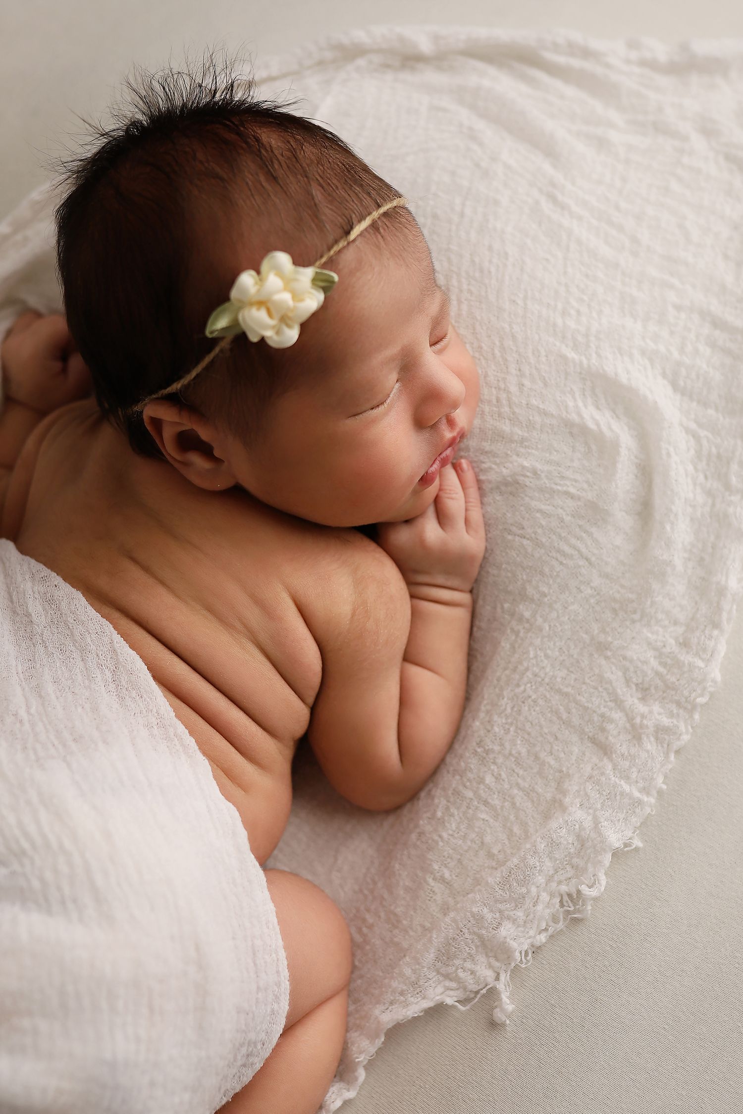 Series of newborn baby portraits on white lace blanket showing delicate details and soft lighting.