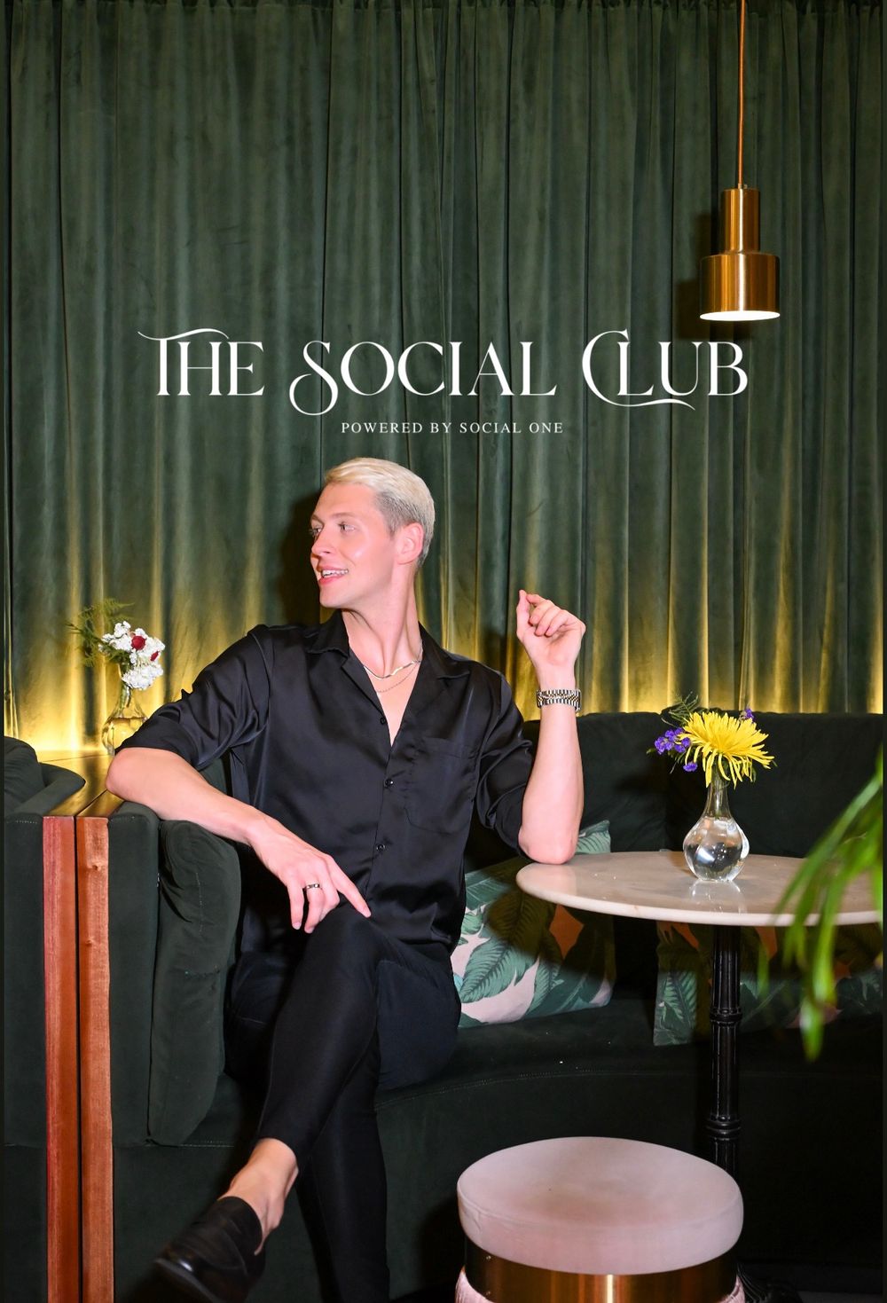 Social club interior scene with black wall paneling and decorative gold lighting fixtures creating an elegant ambiance.